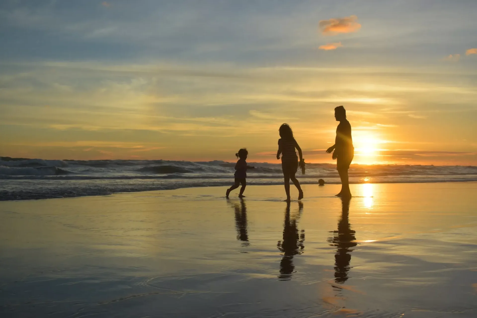 Family walking along the beach at sunset